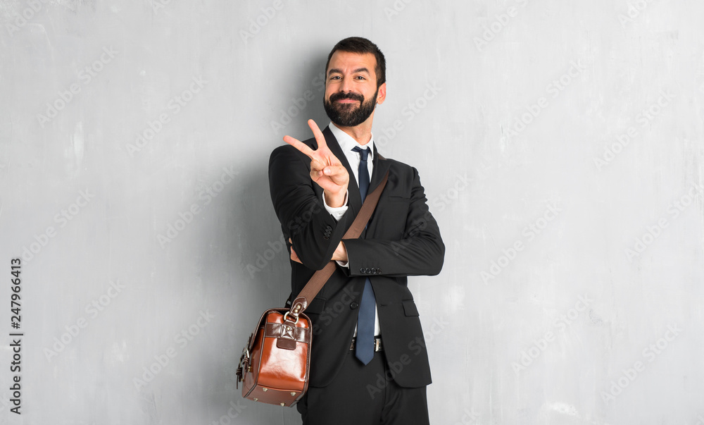 Businessman with beard smiling and showing victory sign Businessman with beard smiling and showing victory sign