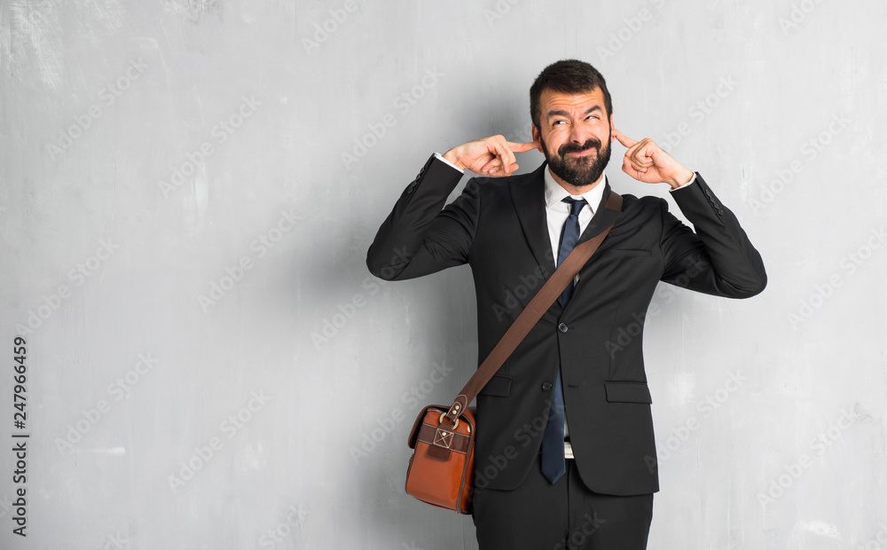 Businessman with beard covering both ears with hands Businessman with beard covering both ears with hands