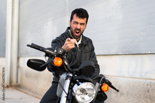 Frustrated young man on a motorbike © luismolinero