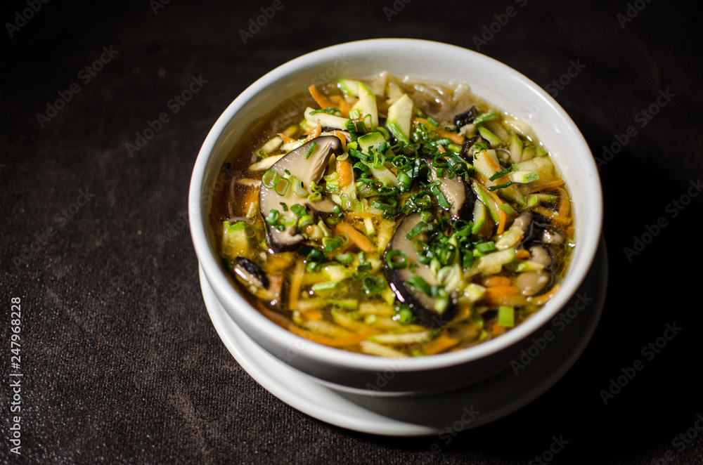 Shiitake soup in white bowl in black background Shiitake soup in white bowl in black background