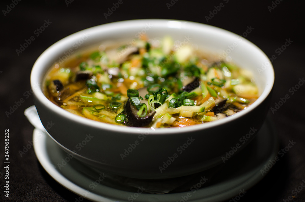 Shiitake soup in white bowl in black background