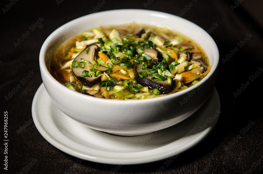 Shiitake soup in white bowl in black background Shiitake soup in white bowl in black background