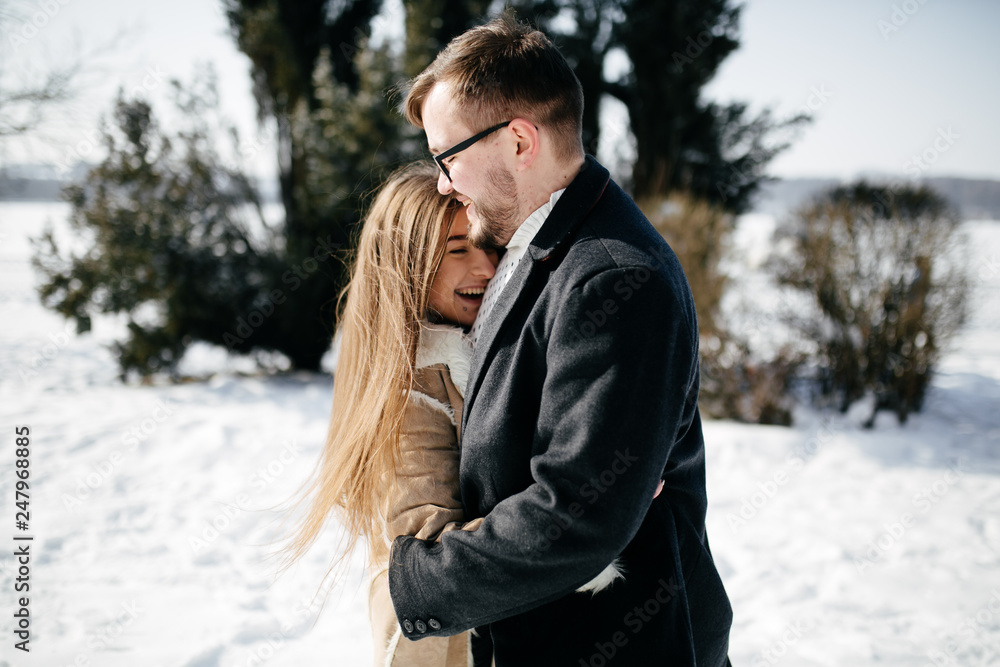 Young Beautiful Couple Taking Fun and Smiling Outdoors in Snowy Winter Young Beautiful Couple Taking Fun and Smiling Outdoors in Snowy Winter