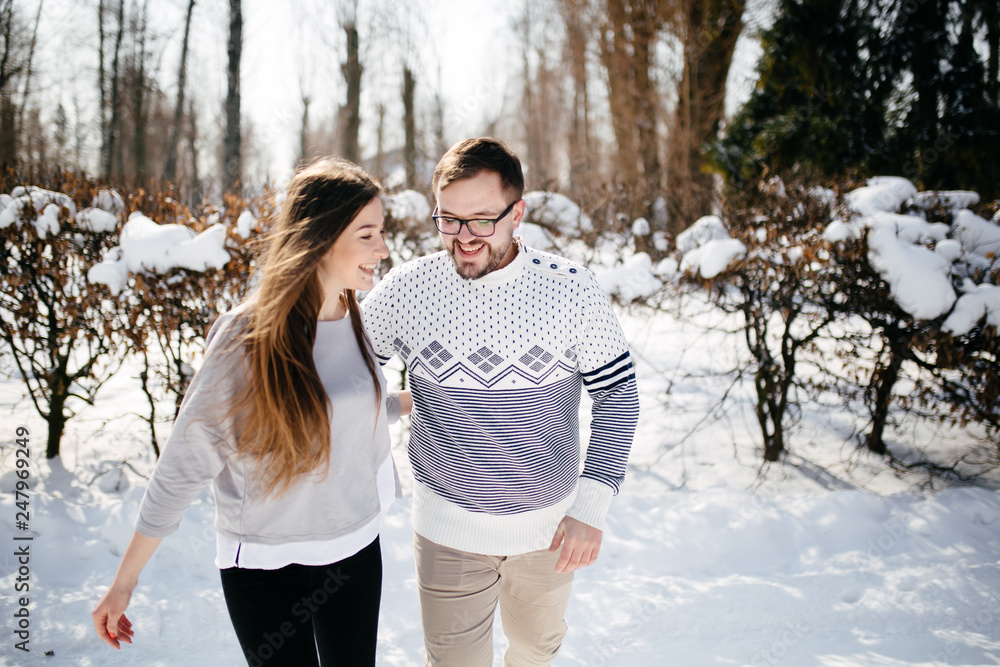 Fototapeta premium Young Beautiful Couple Taking Fun and Smiling Outdoors in Snowy Winter