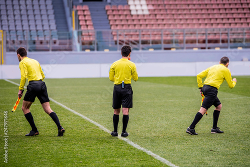 Fototapeta Naklejka Na Ścianę i Meble -  Tree referees at soccer stadium before football match