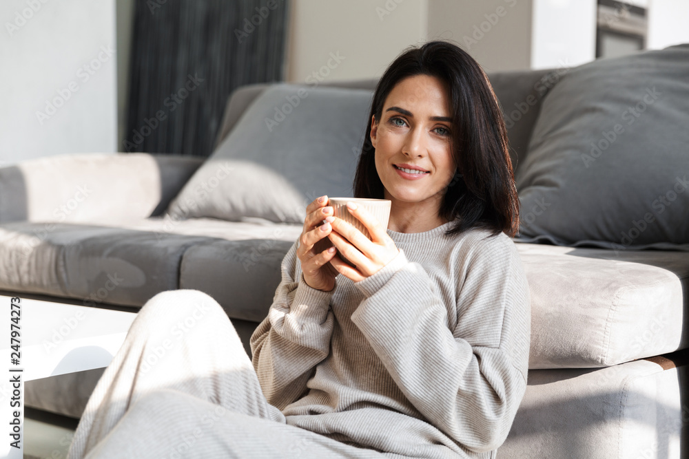 Beautiful young woman relaxing at a couch at home
