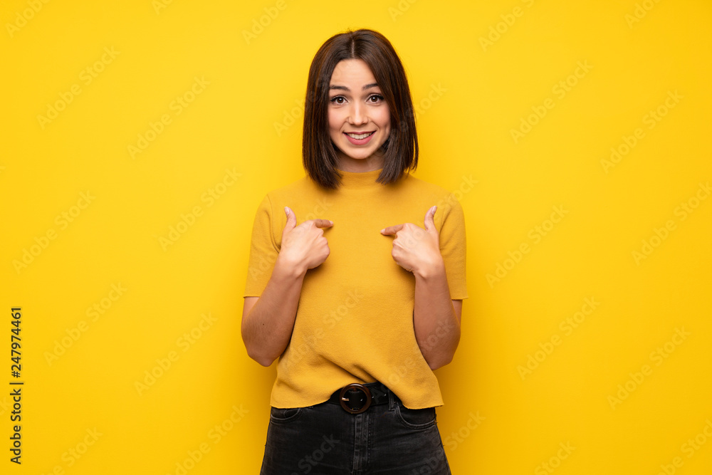 Young woman over yellow wall with surprise facial expression Young woman over yellow wall with surprise facial expression
