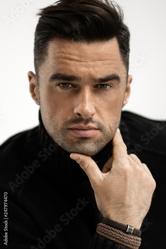 Portrait of handsome man in black turtleneck jumper isolated on white background