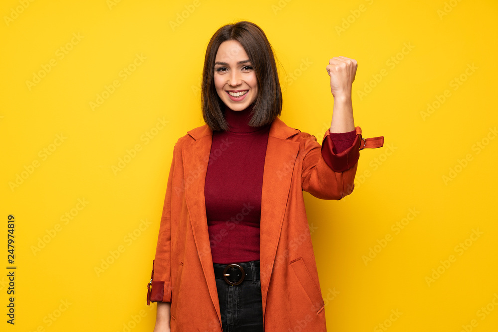 Young woman with coat celebrating a victory in winner position Young woman with coat celebrating a victory in winner position