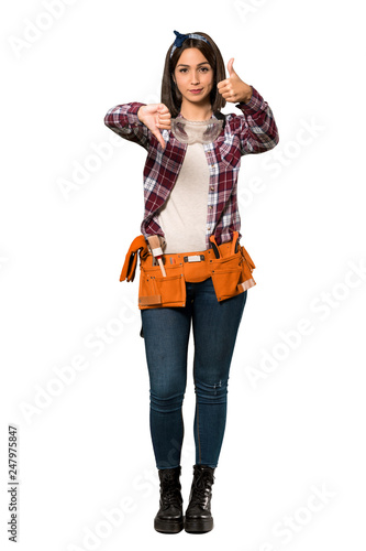 A full-length shot of a Young worker woman making good-bad sign. Undecided between yes or not over isolated white background