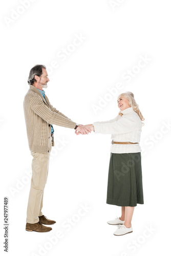 cheerful couple shaking hands isolated on white