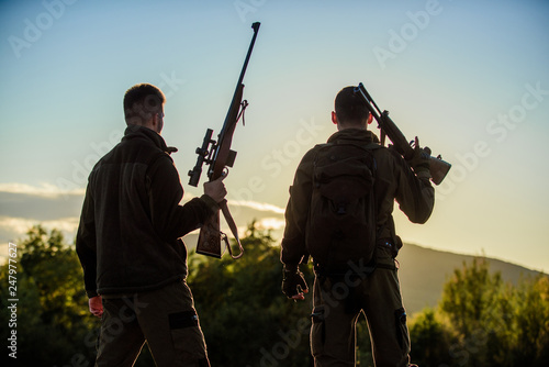 Hunters rifles nature environment. That was great day. Finish hunting season. Enjoy sunset in mountains. Hunters friends enjoy leisure. Hunters friends gamekeepers with guns silhouette sky background