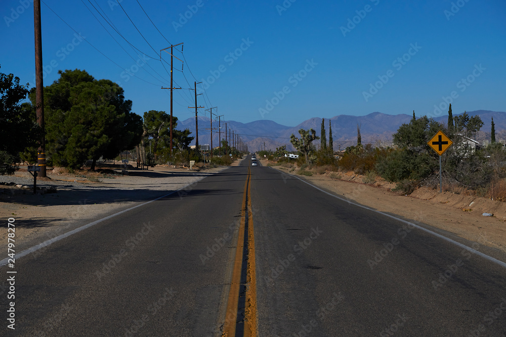 Long winding road through mountain and desert landscape in California
