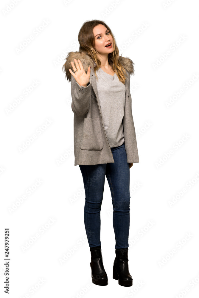A full-length shot of a Teenager girl with coat saluting with hand with happy expression on isolated white background A full-length shot of a Teenager girl with coat saluting with hand with happy expression on isolated white background