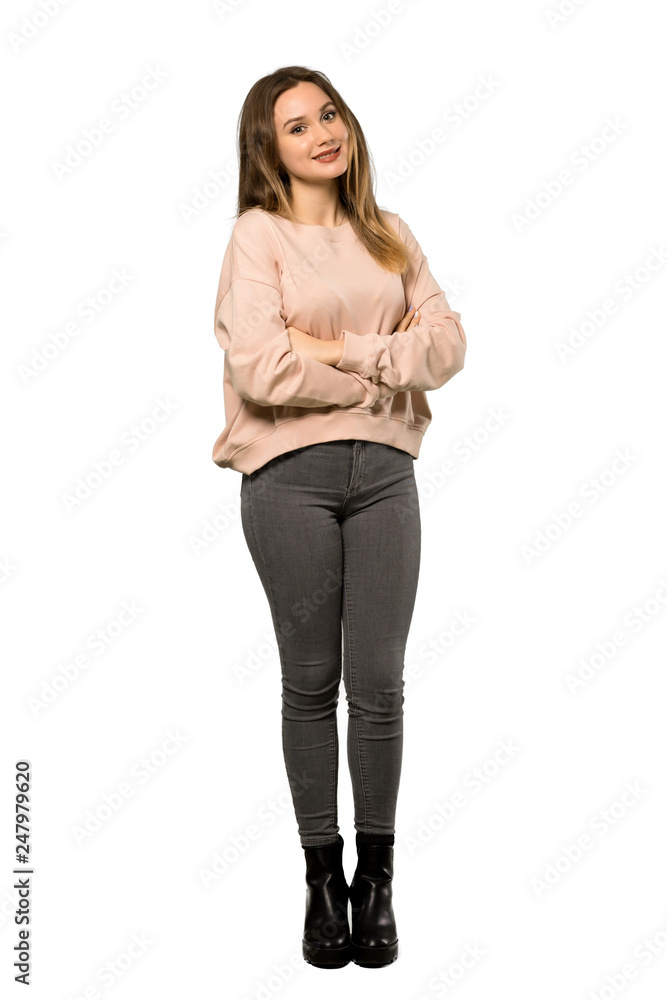 A full-length shot of a Teenager girl with pink sweater keeping the arms crossed in frontal position over isolated white background A full-length shot of a Teenager girl with pink sweater keeping the arms crossed in frontal position over isolated white background