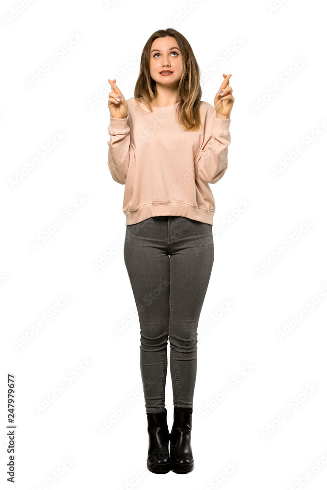 A full-length shot of a Teenager girl with pink sweater with fingers crossing and wishing the best over isolated white background A full-length shot of a Teenager girl with pink sweater with fingers crossing and wishing the best over isolated white background