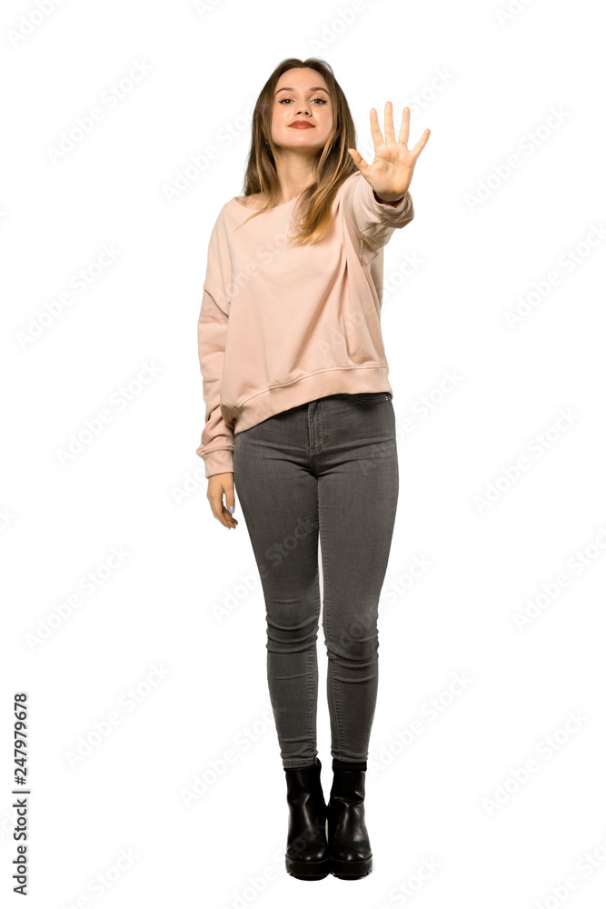A full-length shot of a Teenager girl with pink sweater counting five with fingers over isolated white background A full-length shot of a Teenager girl with pink sweater counting five with fingers over isolated white background