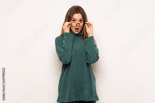 Teenager girl over white wall with glasses and surprised