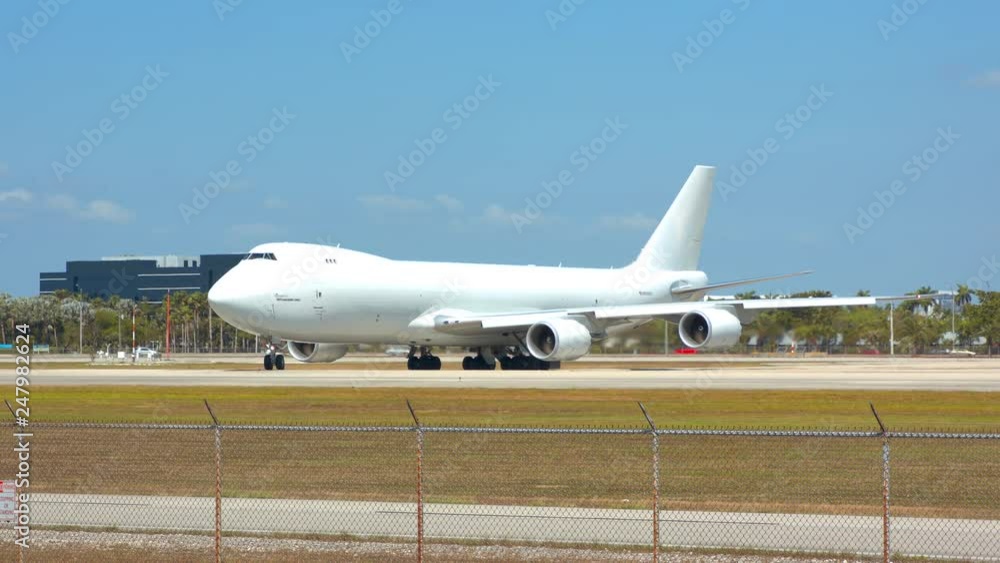 Generic Large Cargo Freighter Airplane with a White Unmarked Livery Ready for Departure Turning onto Airport Runway for Take-off on a Sunny Day Generic Large Cargo Freighter Airplane with a White Unmarked Livery Ready for Departure Turning onto Airport Runway for Take-off on a Sunny Day