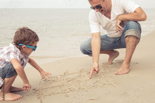 Father and son playing on the beach at the day time.