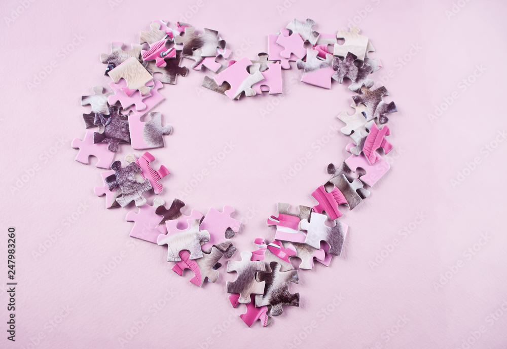 heart made from the puzzle on the pink background