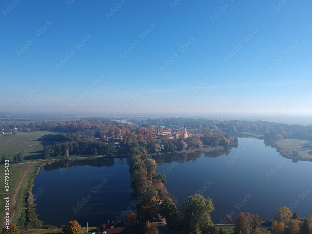 Drone photo of Nesvizh Castle in autumn on a hazy day. Minsk Region, Belarus. Site of residential castle of the Radziwill family. 