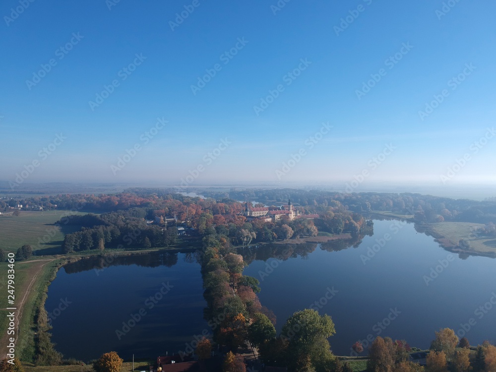 Drone photo of Nesvizh Castle in autumn on a hazy day. Minsk Region, Belarus. Site of residential castle of the Radziwill family. 