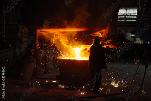 Steelmaker at ingot casting. Electric arc furnace shop EAF. Metallurgical production.