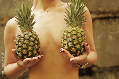 Blond girl posing for photo at forest with pineapple
