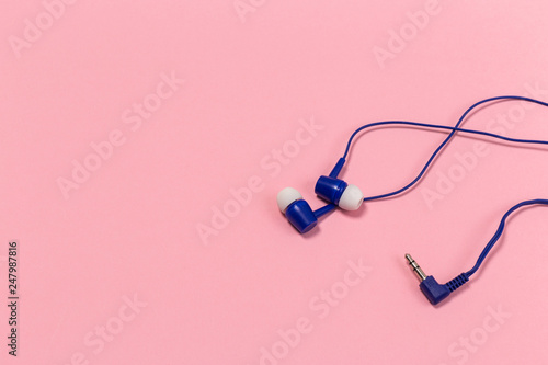 blue headphones on pastel background. White headphones on a pink background. Top view.
