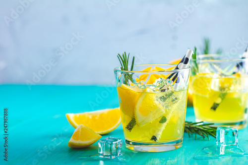 Lemon alcohol drink cocktail with ice, lemon and rosemary