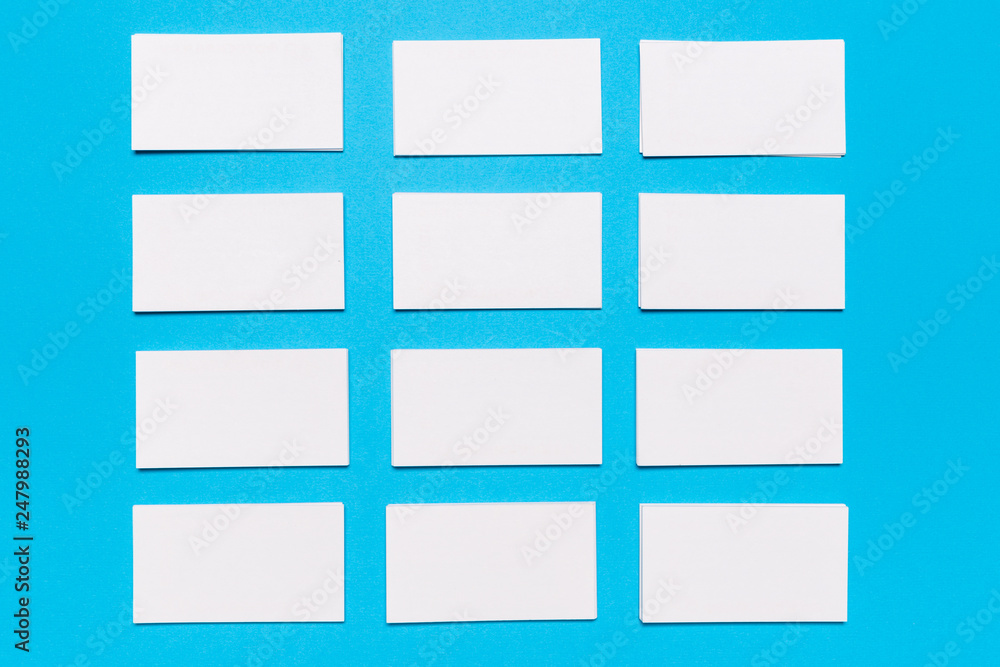 Blank white business cards on blue background. Mockup for branding identity.