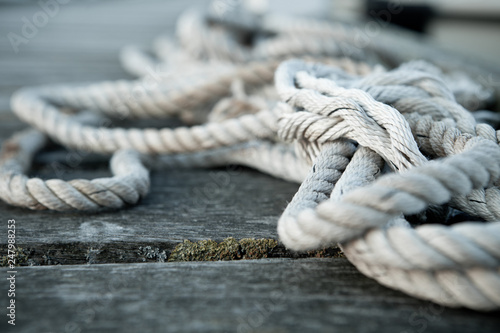 Close up of a sailing rope on a wooden pier with depth of fields 