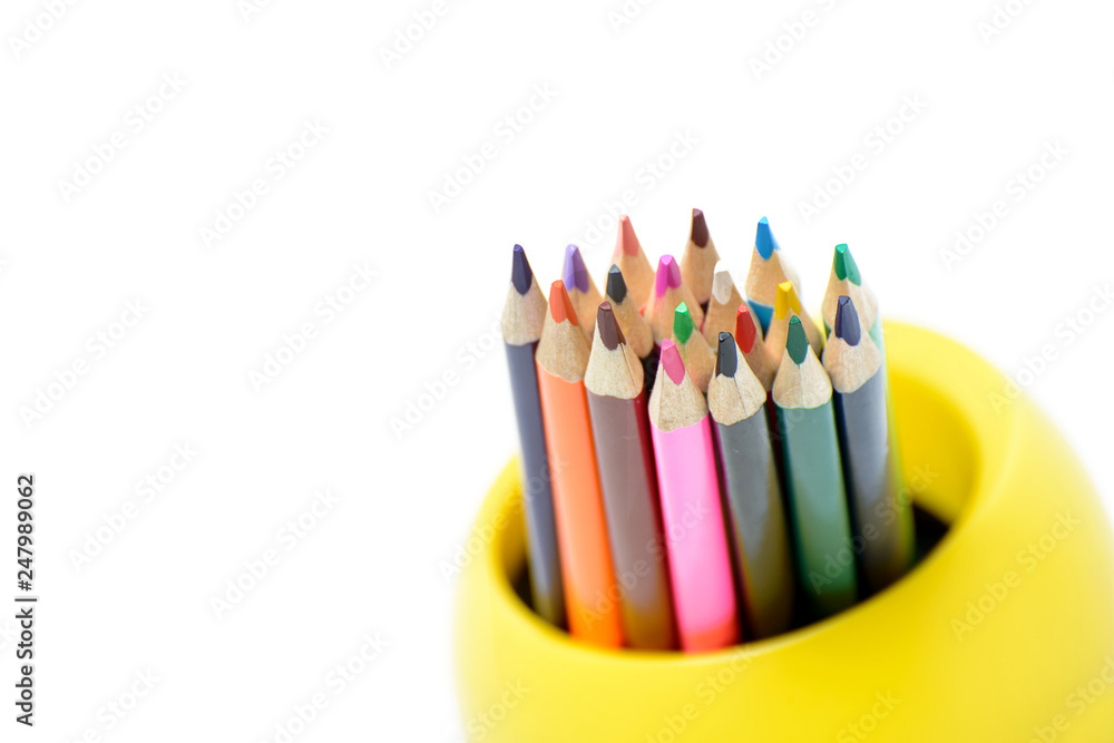 Colored pencils in a glass on a white background Colored pencils in a glass on a white background