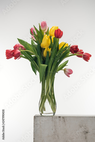 bouquet of tulips in glass vase on white