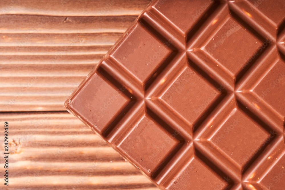 Milk chocolate bar on wooden background, macro photo Milk chocolate bar on wooden background, macro photo