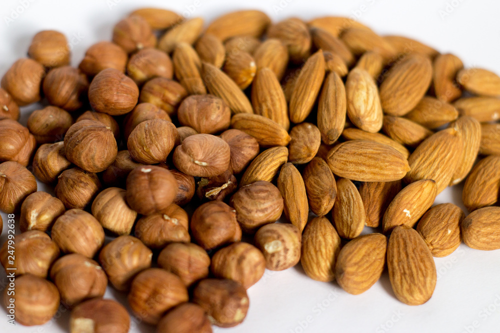 handful of nuts on a white background, almonds and hazelnuts handful of nuts on a white background, almonds and hazelnuts