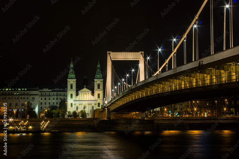 Fototapeta premium View of City Mother Church of the Blessed Virgin and Elisabeth Bridge in Budapest at night. Hungary