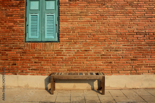 Wooden chair with vintage red brick wall and blue window. Vintage background
