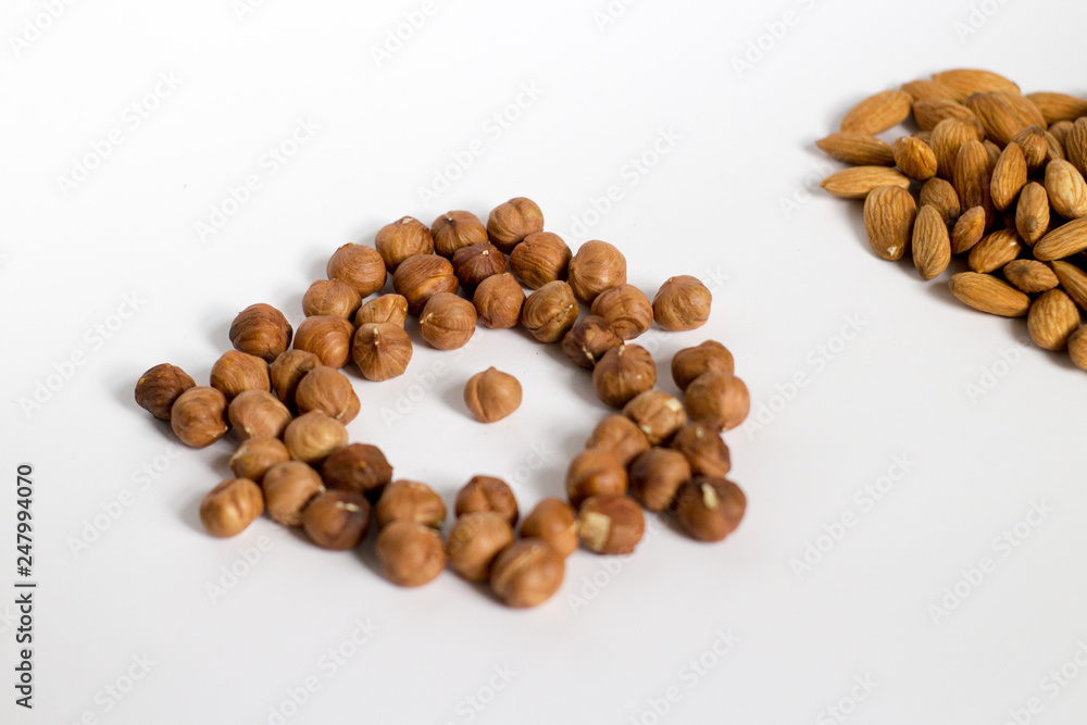 handful of nuts on a white background, almonds and hazelnuts, nest handful of nuts on a white background, almonds and hazelnuts, nest