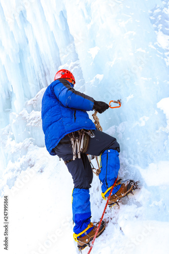 ice climber checks the reliability of the anchor