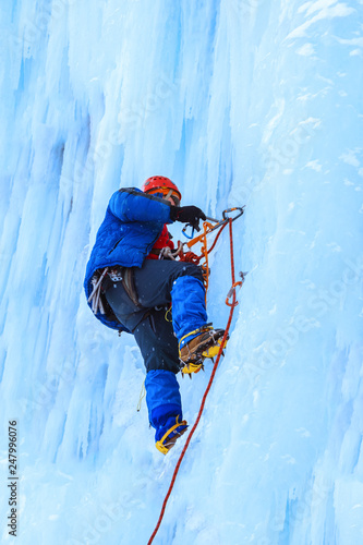 ice climber rises on a vertical glacier wall