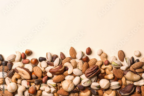 Flat lay composition with organic mixed nuts and space for text on color background photo