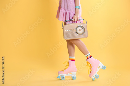Young woman with roller skates and retro radio on color background, closeup. Space for text