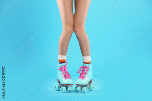 Fototapeta Naklejka Na Ścianę i Meble -  Young woman with retro roller skates on color background, closeup