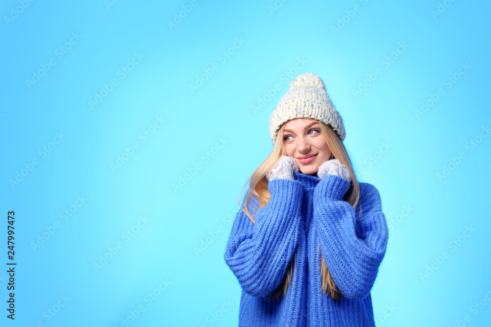 Portrait of emotional young woman in stylish hat, sweater and mittens on color background, space for text. Winter atmosphere Portrait of emotional young woman in stylish hat, sweater and mittens on color background, space for text. Winter atmosphere