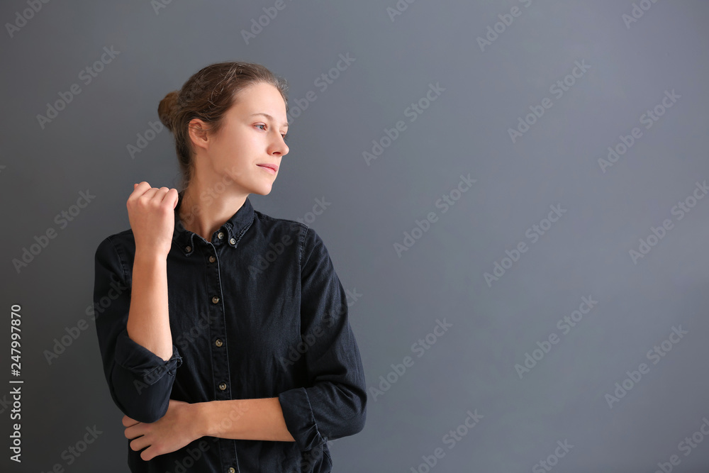 Beautiful young woman on grey background