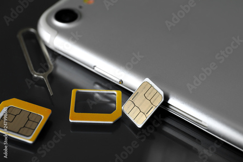 Canvastavla Mobile phone with sim cards and key on dark table