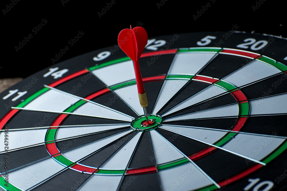 Close up shot red dart arrow on center of dartboard, metaphor to target success, winner concept, Isolated on white background with clipping path Close up shot red dart arrow on center of dartboard, metaphor to target success, winner concept, Isolated on white background with clipping path