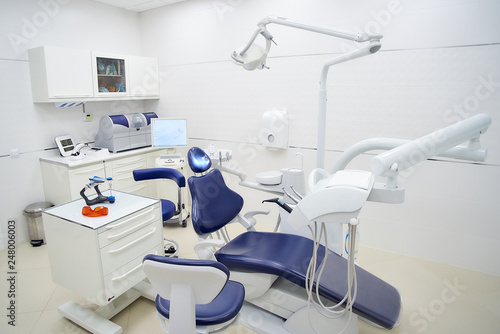 New white interior of a dental office, dental chair, wet milling and grinding machine, intra oral scanner. Dentist’s office. Dental laboratory